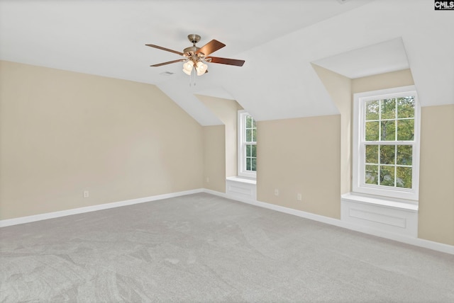 additional living space with ceiling fan, light colored carpet, and vaulted ceiling