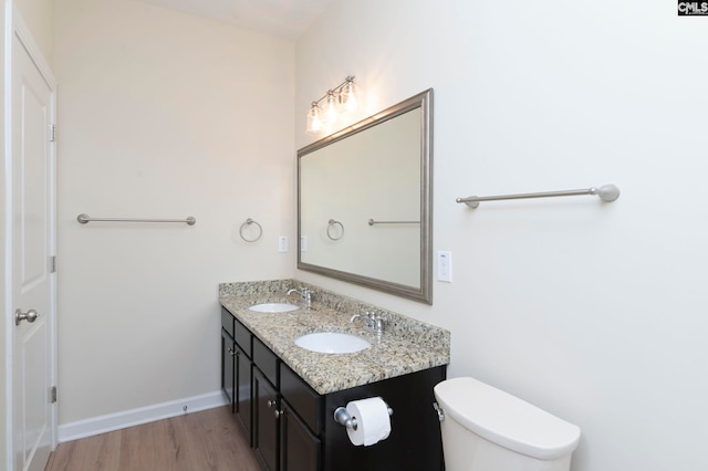 bathroom with hardwood / wood-style flooring, vanity, and toilet