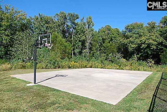 view of sport court with a lawn