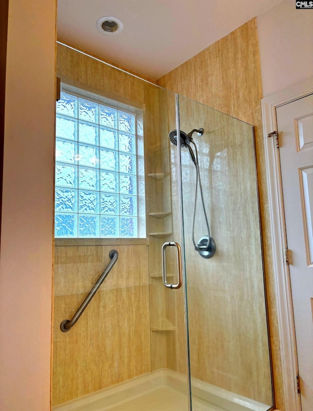 bathroom featuring a shower with door