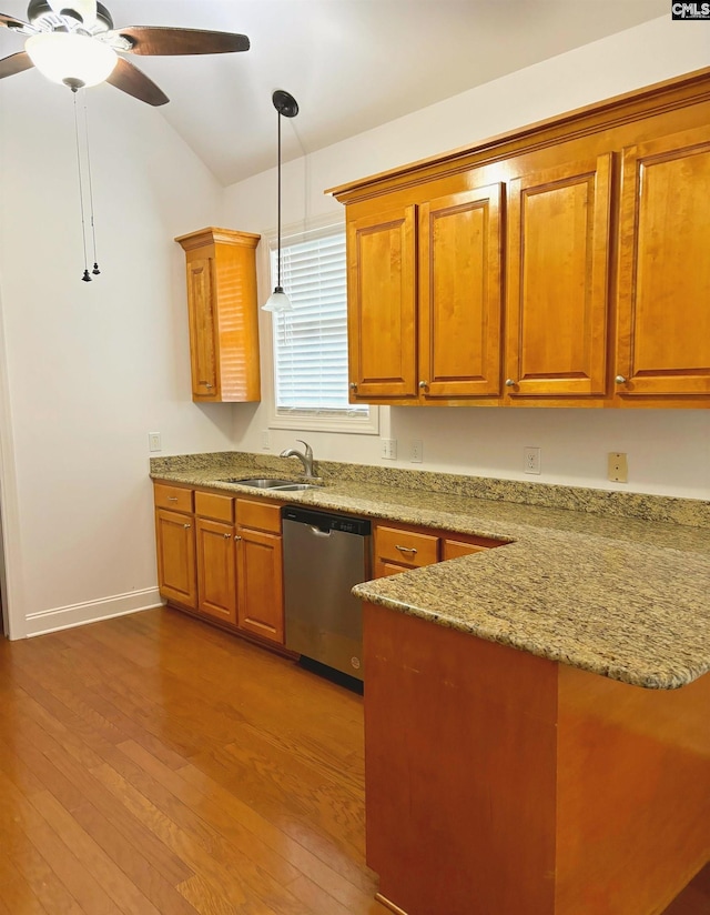 kitchen with pendant lighting, hardwood / wood-style floors, sink, stainless steel dishwasher, and lofted ceiling