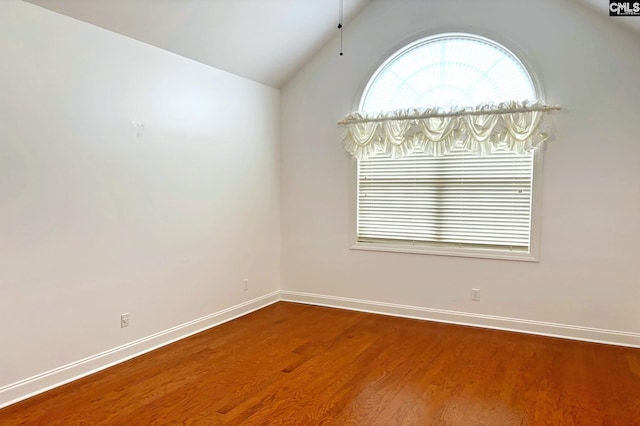 spare room with hardwood / wood-style floors and lofted ceiling