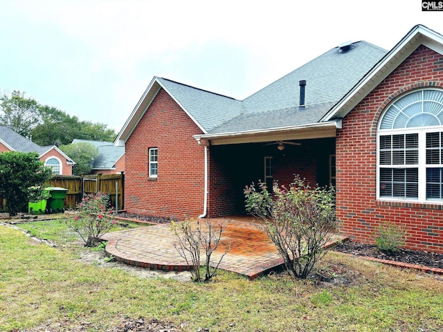 view of property exterior featuring a patio, a yard, and ceiling fan