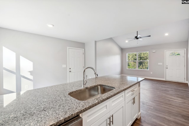 kitchen with white cabinets, ceiling fan, light stone countertops, and sink