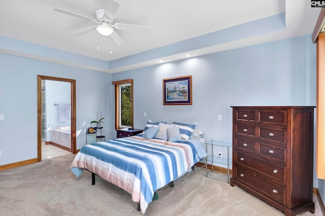 bedroom with ensuite bathroom, ceiling fan, and light colored carpet