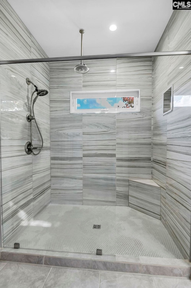 bathroom featuring tile patterned flooring and a tile shower