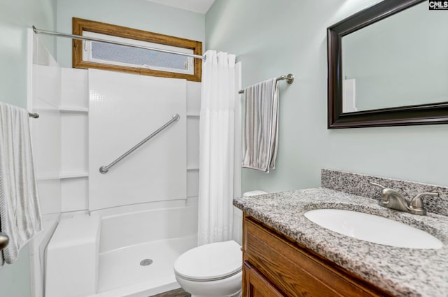 bathroom featuring toilet, vanity, and a shower with shower curtain