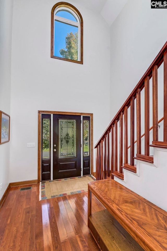 entryway featuring hardwood / wood-style flooring and vaulted ceiling