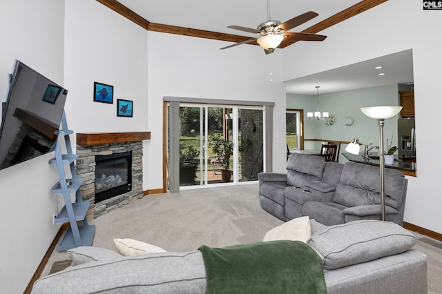 carpeted living room with a stone fireplace, a towering ceiling, ceiling fan with notable chandelier, and crown molding