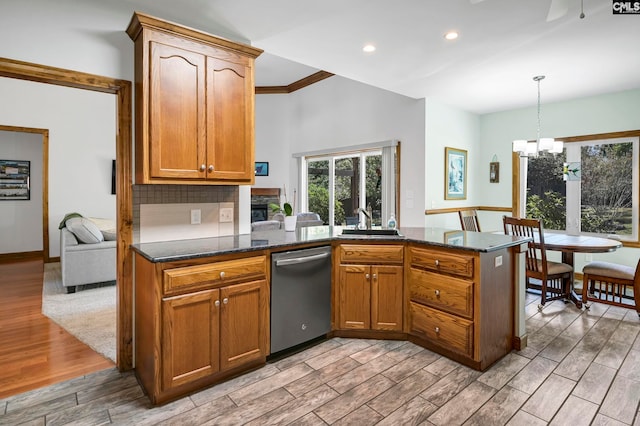 kitchen featuring light hardwood / wood-style floors, kitchen peninsula, dark stone countertops, hanging light fixtures, and dishwasher