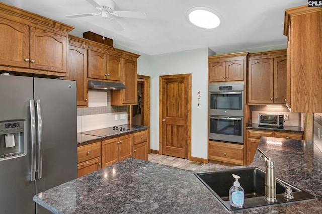 kitchen with sink, appliances with stainless steel finishes, ceiling fan, light wood-type flooring, and decorative backsplash