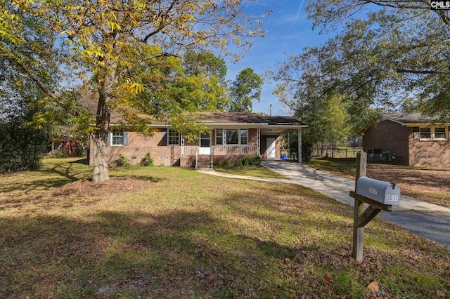 ranch-style home featuring a carport, a front yard, and covered porch