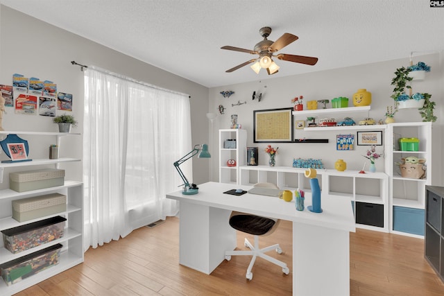 office area featuring ceiling fan, a textured ceiling, and light hardwood / wood-style floors