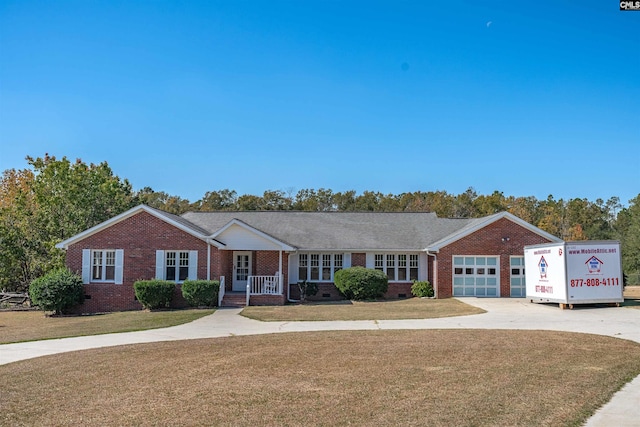 ranch-style house with covered porch, a garage, and a front lawn