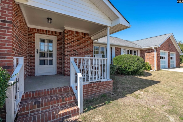 doorway to property featuring covered porch and a lawn