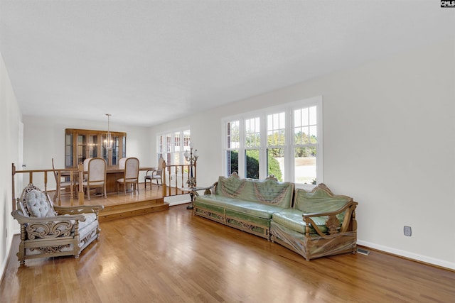 living room featuring wood-type flooring and a chandelier