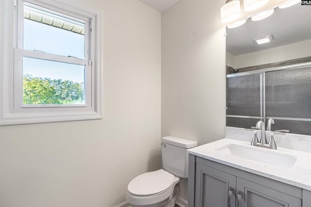 bathroom featuring toilet, vanity, and walk in shower