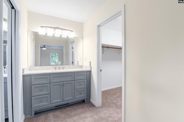 bathroom with a textured ceiling, vanity, and ceiling fan