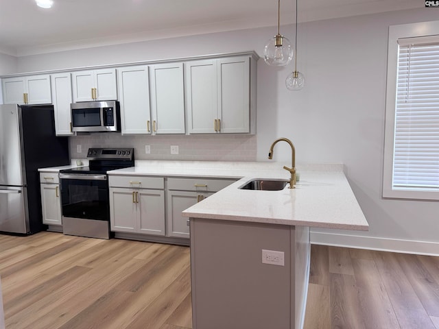 kitchen with light stone counters, light hardwood / wood-style floors, pendant lighting, decorative backsplash, and appliances with stainless steel finishes