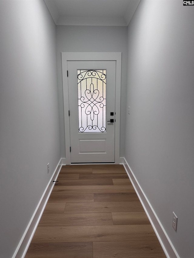 doorway to outside with hardwood / wood-style flooring and crown molding