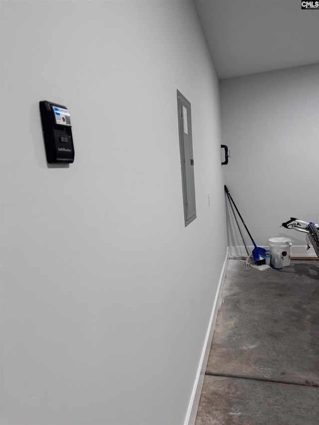 corridor featuring electric panel and concrete floors