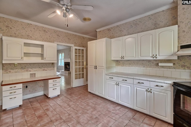 115 Cedar Lake Rd, Blythewood, SC 29016 - kitchen with wallpapered walls, tile countertops, open shelves, ornamental molding, and black range with electric stovetop