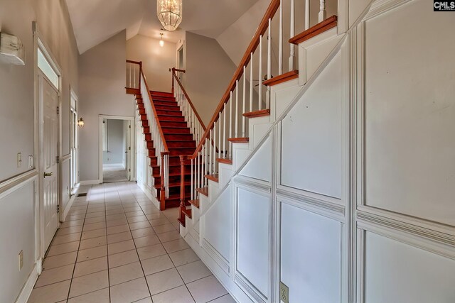 115 Cedar Lake Rd, Blythewood, SC 29016 - stairs featuring tile patterned floors, high vaulted ceiling, and baseboards