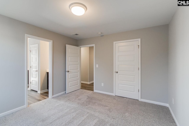 unfurnished bedroom featuring carpet floors, visible vents, and baseboards