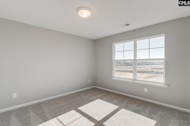 unfurnished room with carpet floors, visible vents, and baseboards