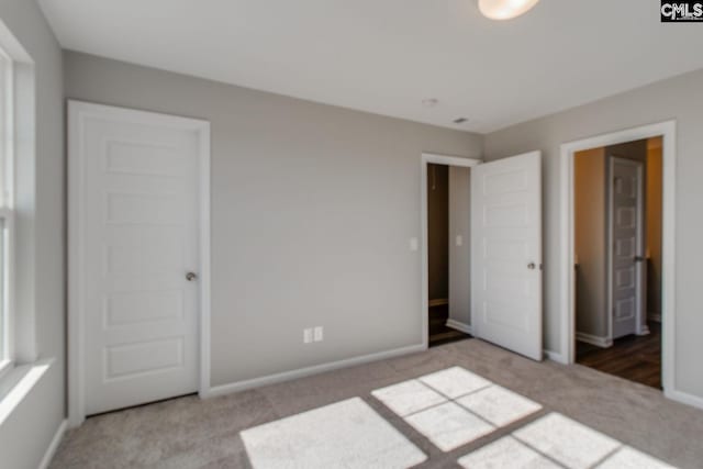 unfurnished bedroom with carpet and baseboards