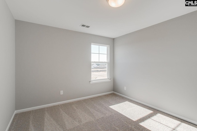 carpeted empty room with visible vents and baseboards