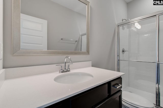 full bathroom featuring a stall shower, vanity, and toilet