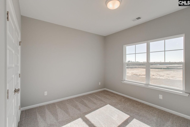 carpeted spare room with baseboards and visible vents