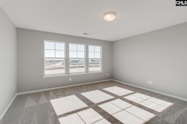 unfurnished room featuring carpet floors, baseboards, and visible vents