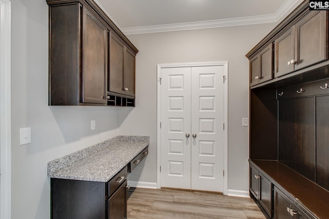 mudroom featuring light wood-type flooring, crown molding, and baseboards