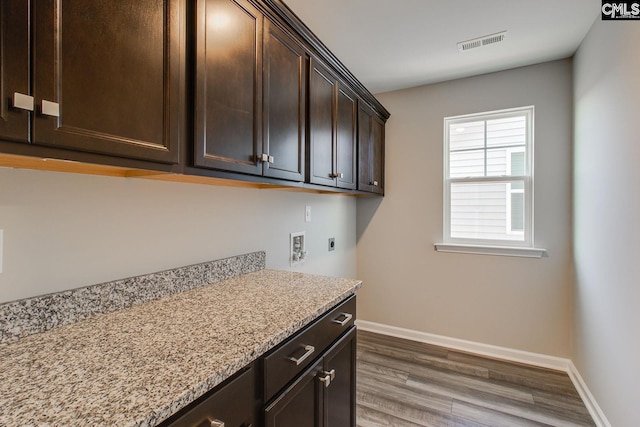 washroom featuring cabinet space, baseboards, visible vents, wood finished floors, and hookup for an electric dryer