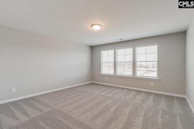 carpeted spare room featuring visible vents and baseboards