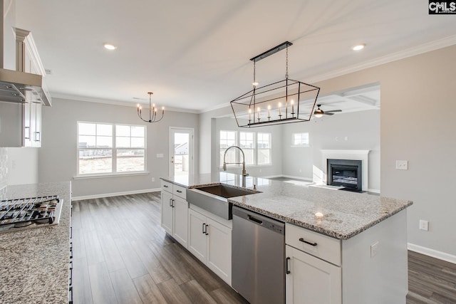 kitchen featuring stainless steel appliances, crown molding, a sink, and wall chimney exhaust hood