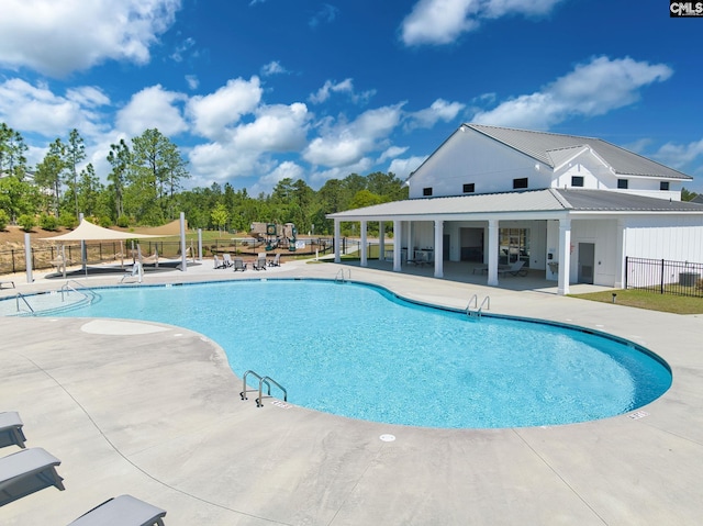 pool with a patio area and fence