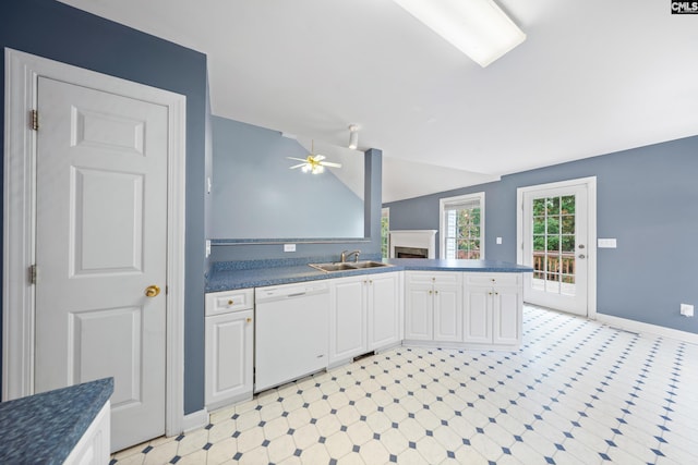 kitchen featuring lofted ceiling, dishwasher, white cabinets, sink, and ceiling fan