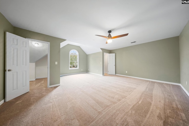 spare room with light colored carpet, ceiling fan, and vaulted ceiling