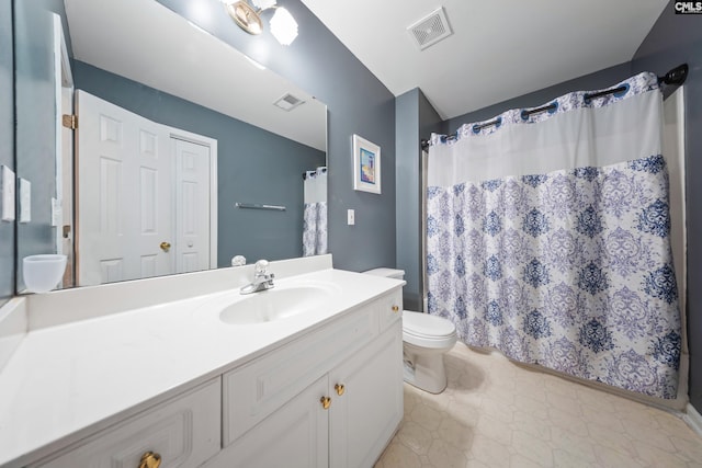 bathroom featuring toilet, vanity, and curtained shower