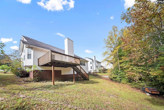 rear view of house with a lawn and a deck