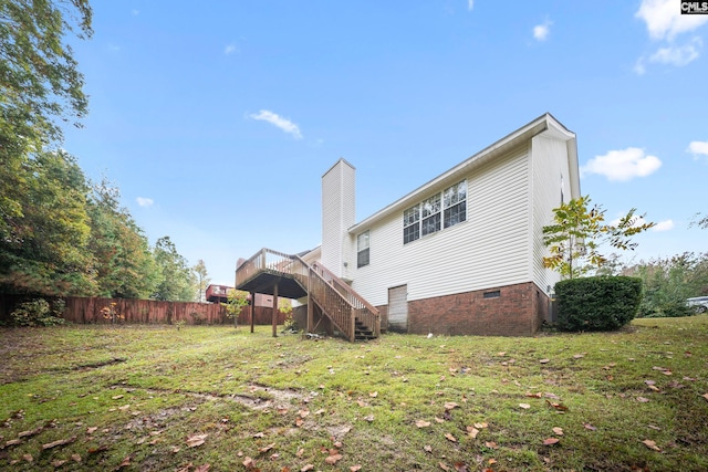 back of property with a lawn and a deck