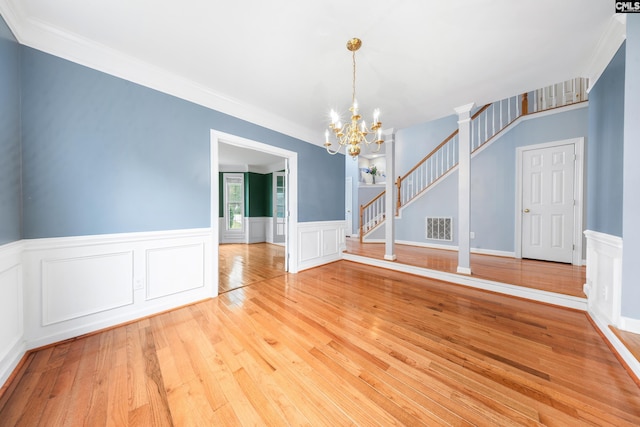 spare room featuring light hardwood / wood-style floors, a notable chandelier, and crown molding