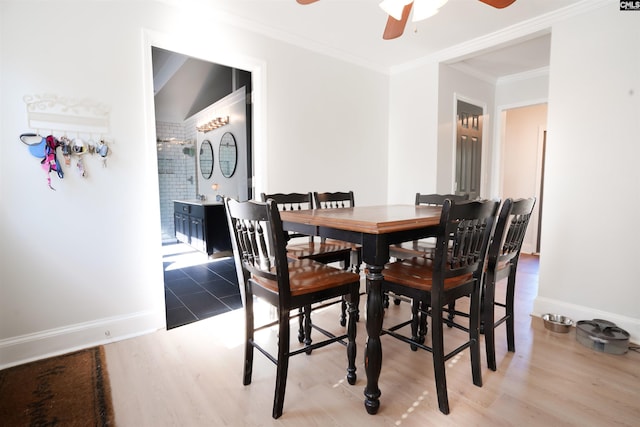 dining room with light hardwood / wood-style floors, ceiling fan, crown molding, and vaulted ceiling