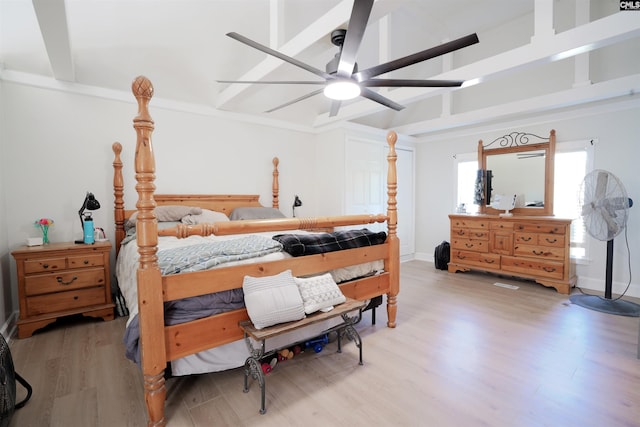 bedroom featuring beamed ceiling, light wood-style flooring, and a ceiling fan