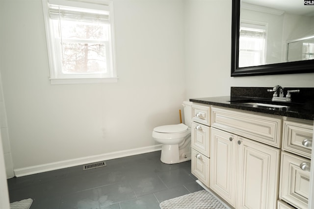 bathroom with tile patterned floors, toilet, a shower with door, baseboards, and vanity