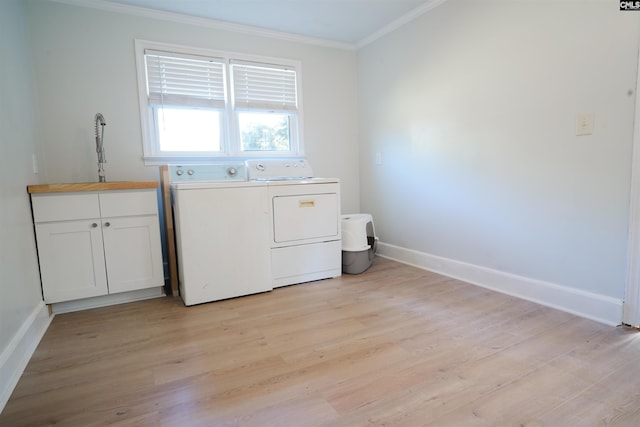 laundry room with light wood-type flooring, cabinets, washer and dryer, and ornamental molding