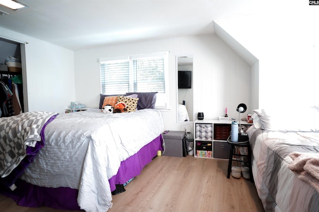 bedroom featuring light hardwood / wood-style floors and lofted ceiling